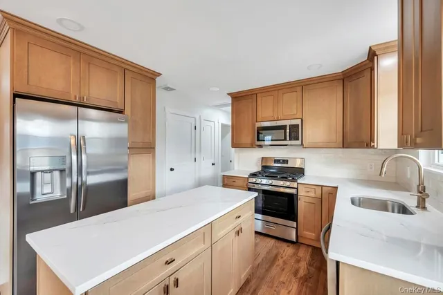 a kitchen and a refrigerator in a room with wooden floor