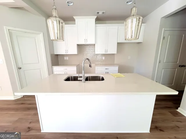 a kitchen with kitchen island a sink a stove a refrigerator and cabinetry