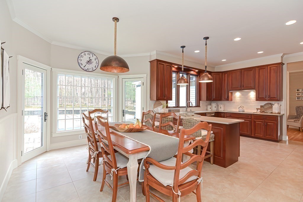 17 Elizabeth Road Hopkinton, MA 01748 - Photo 21 of 40 a kitchen with a dining table chairs sink and stove