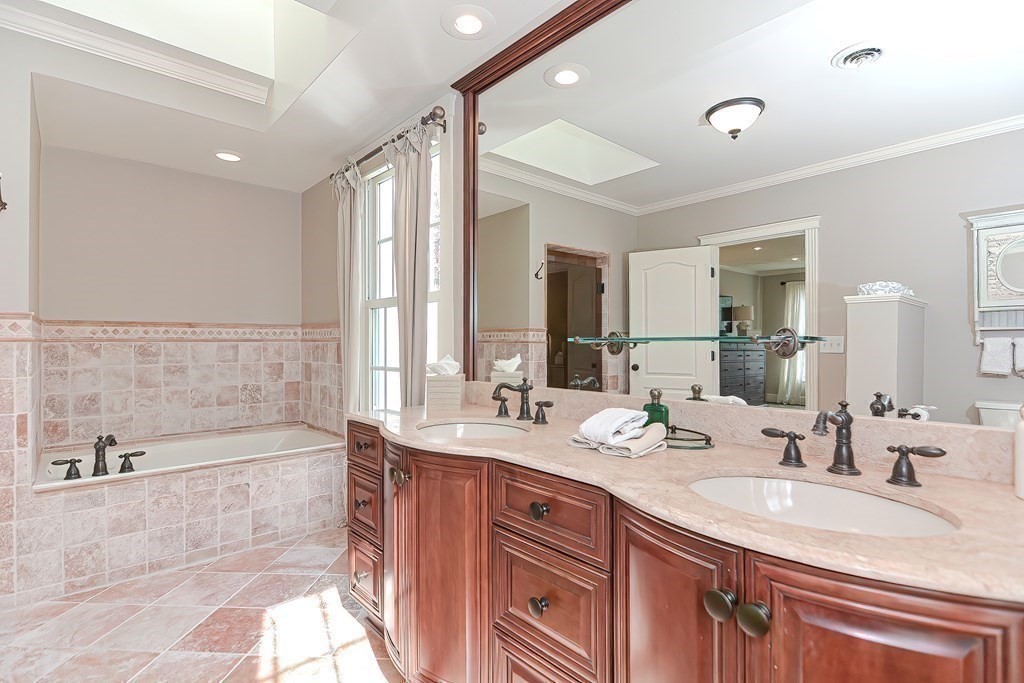 17 Elizabeth Road Hopkinton, MA 01748 - Photo 29 of 40 a bathroom with a double vanity sink large mirror and a bathtub