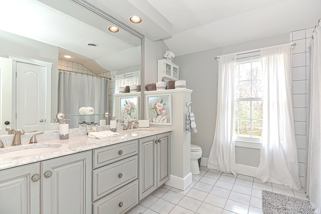 17 Elizabeth Road Hopkinton, MA 01748 - Photo 33 of 40 a bathroom with a double vanity sink a mirror and a toilet