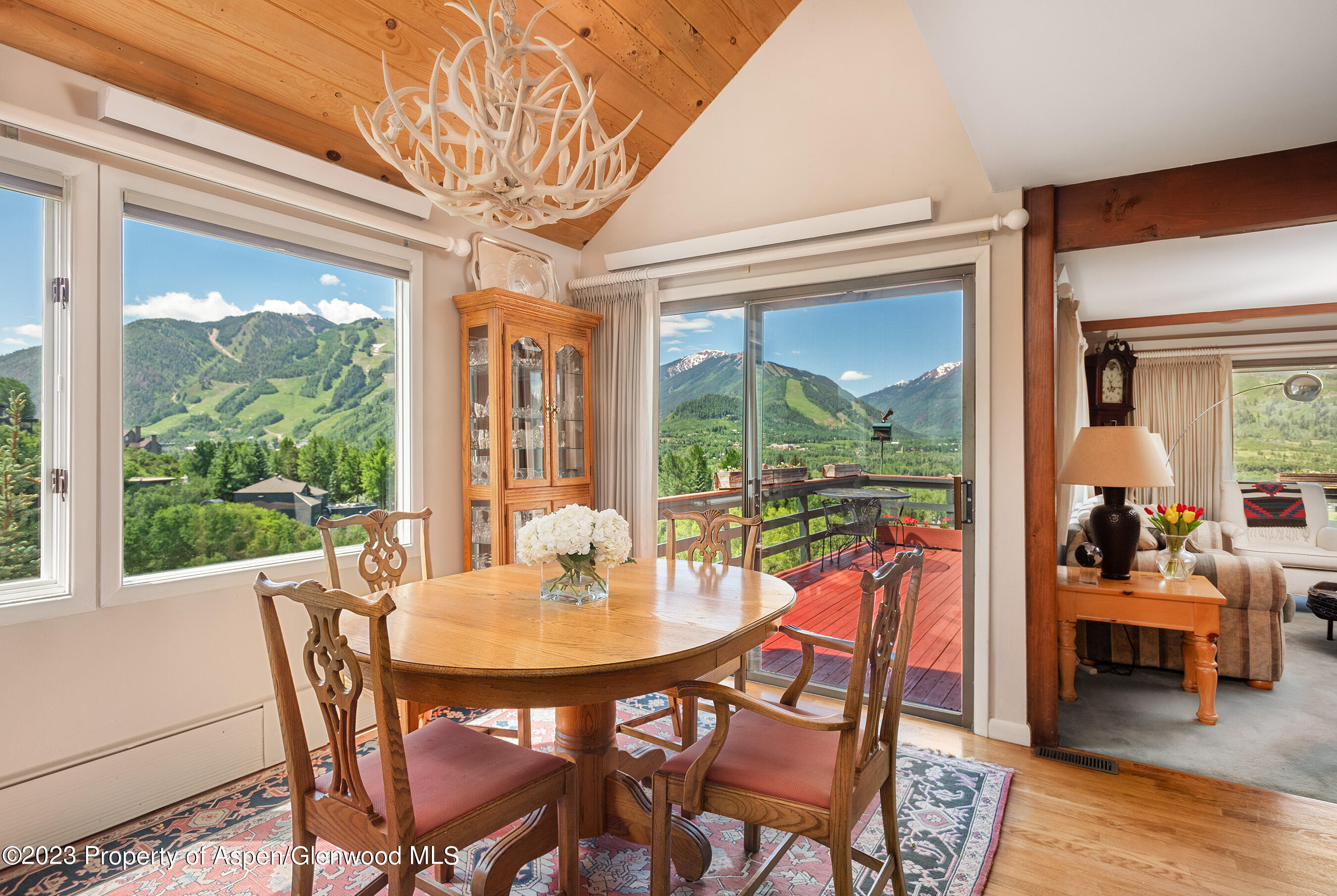 a dining room with furniture a chandelier and wooden floor