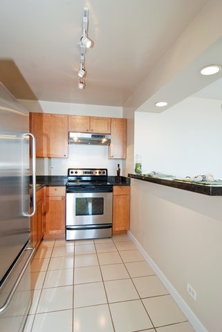 655 West Irving Park Road, Unit 3614 Chicago, IL 60613 - Photo 6 of 10 a kitchen with granite countertop a stove and a refrigerator