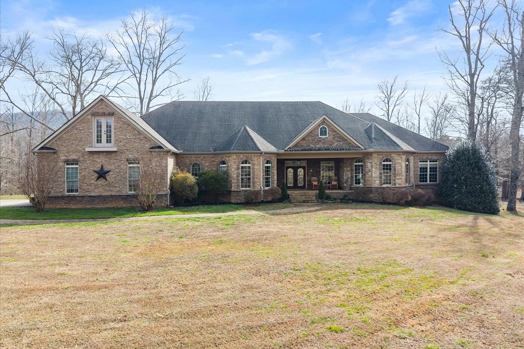 a front view of a house with a garden and tree