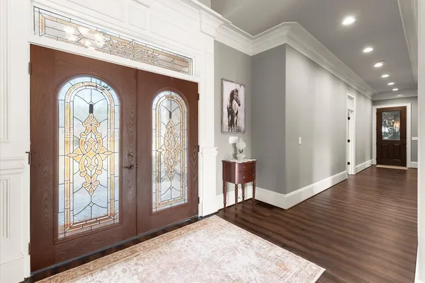a view of a hallway with entryway wooden floor and front door