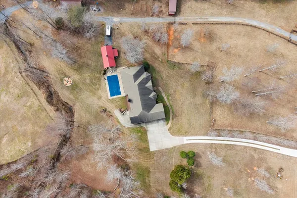 a view of a big house with a big yard and large trees