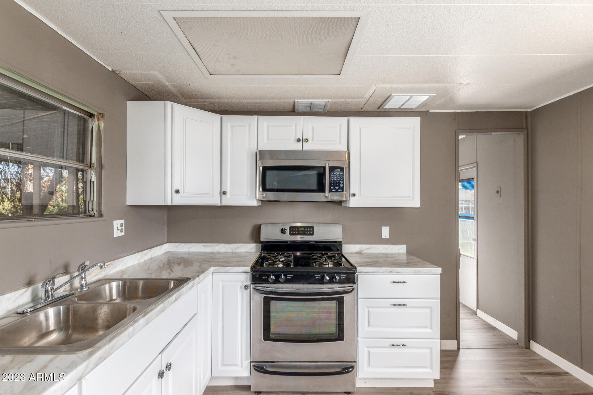 6633 West Nancy Road Glendale, AZ 85306 - Photo 9 of 29 a kitchen with granite countertop a sink stove and microwave
