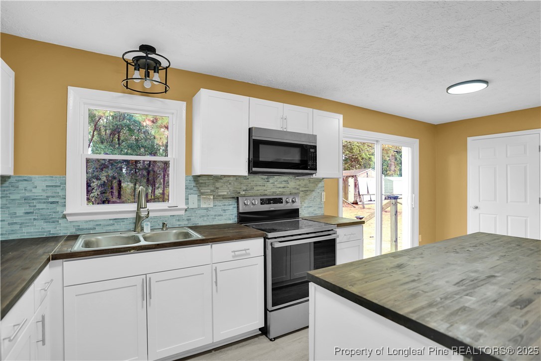 2218 Chason Road Lumber Bridge, NC 28357 - Photo 11 of 22 a kitchen with granite countertop a sink stainless steel appliances and a window
