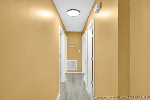 a view of a hallway with wooden floor