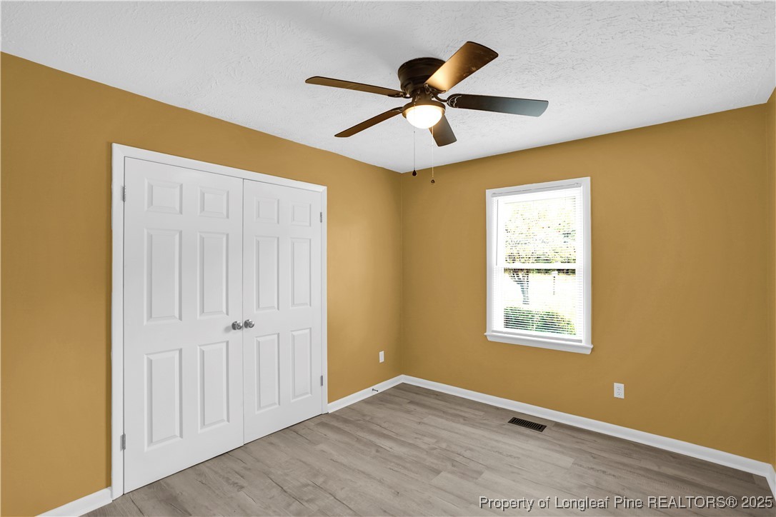 2218 Chason Road Lumber Bridge, NC 28357 - Photo 14 of 22 a view of a big room with wooden floor closet and windows