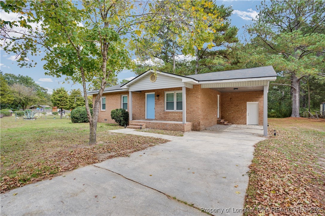 2218 Chason Road Lumber Bridge, NC 28357 - Photo 2 of 22 a front view of a house with a garden and trees