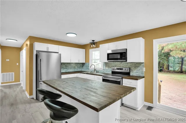 a kitchen with stainless steel appliances granite countertop a stove refrigerator and microwave