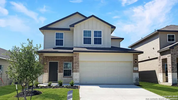 a view of a house with a yard and large tree