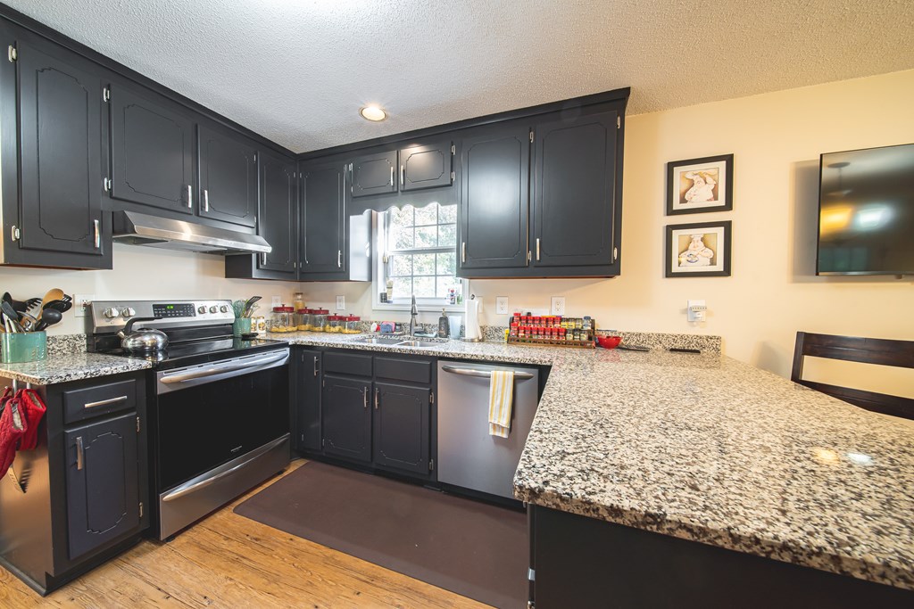 200 Lake Amah Lee Road Hampton, GA 30228 - Photo 13 of 29 a kitchen with granite countertop wooden cabinets and stainless steel appliances