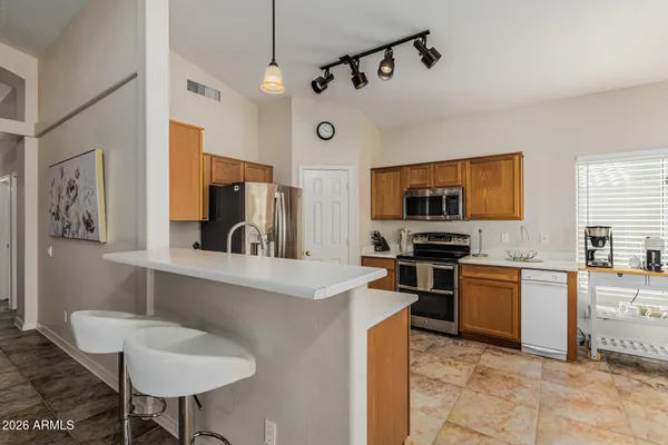 a kitchen with stainless steel appliances granite countertop a sink and a refrigerator