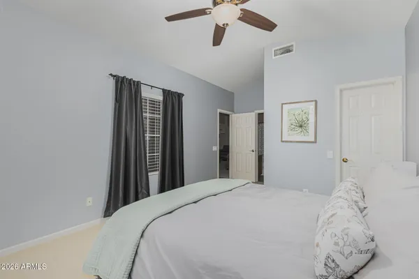 a bedroom with a large bed and a chandelier
