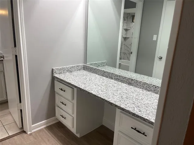 a bathroom with a granite countertop sink and a mirror