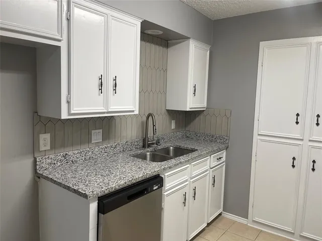 a kitchen with stainless steel appliances granite countertop a sink and dishwasher with wooden cabinets