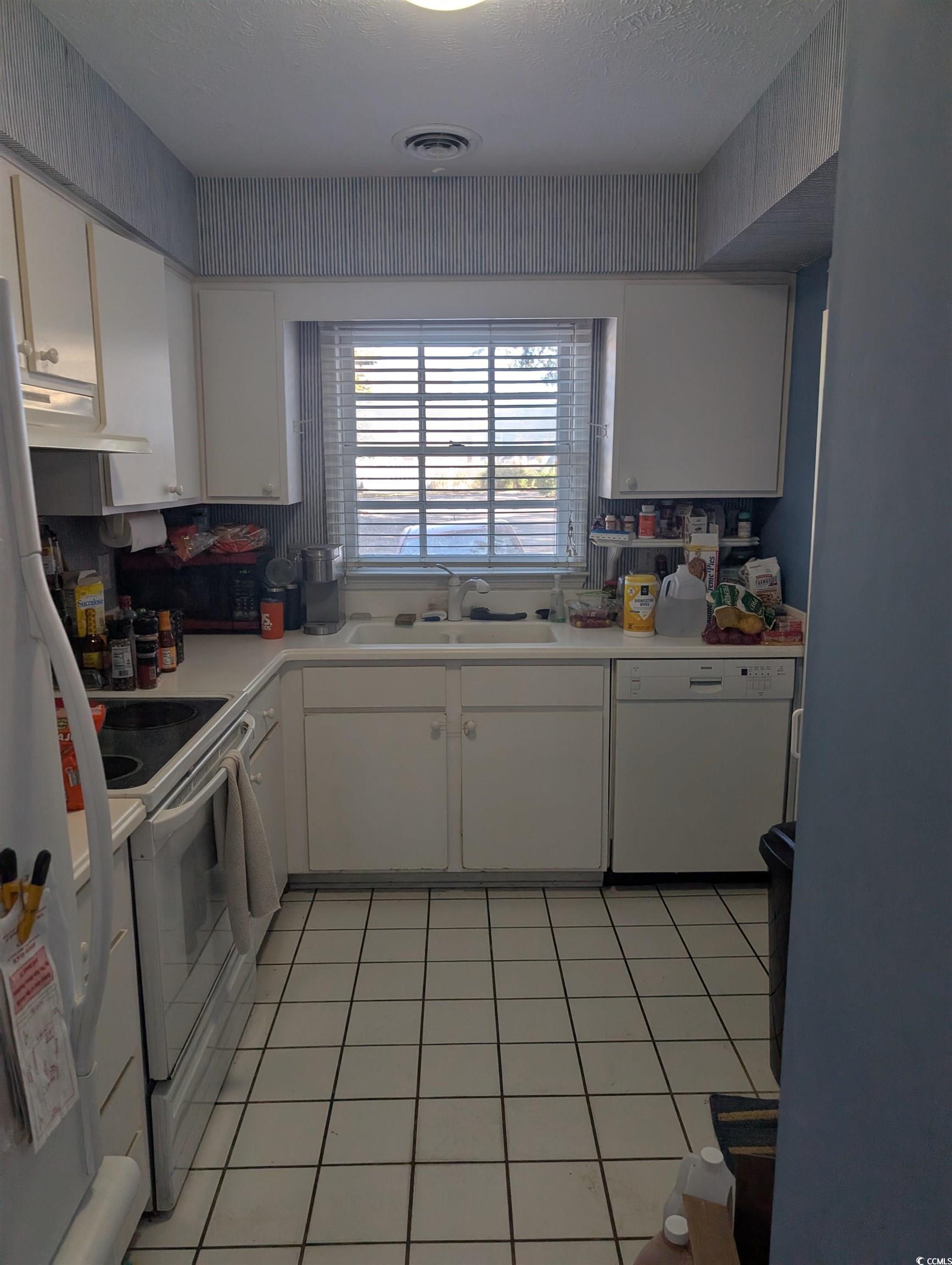 830 North 44th Avenue North, Unit O2 Myrtle Beach, SC 29577 - Photo 4 of 11 Kitchen with white appliances, white cabinetry, si