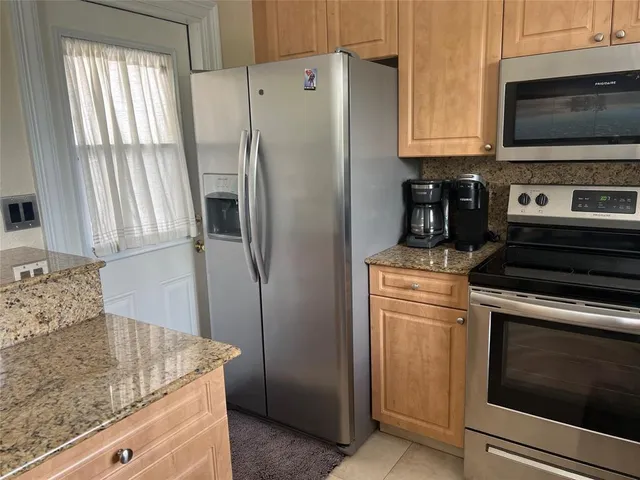 a kitchen with stainless steel appliances granite countertop a refrigerator stove and microwave