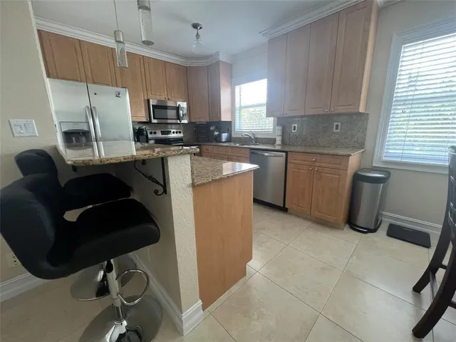 a kitchen with granite countertop a sink appliances a window and a counter top space