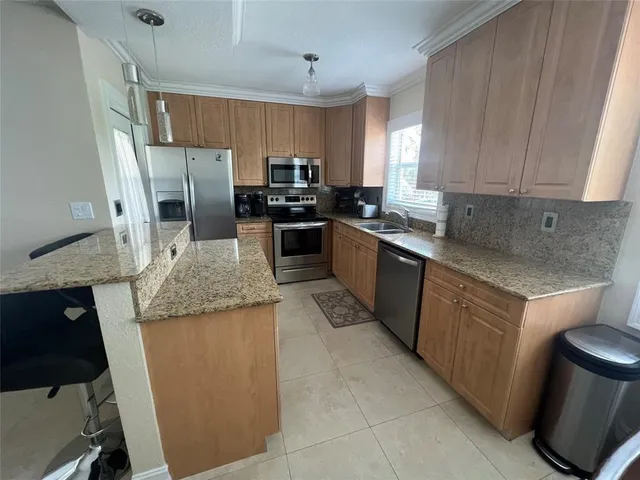 a kitchen with granite countertop stainless steel appliances and wooden cabinets
