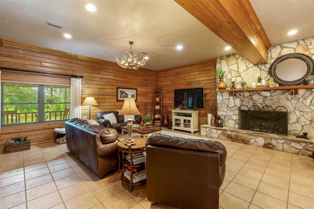 3771 184th Street Wellborn, FL 32094 - Photo 16 of 74 a living room with furniture a fireplace and a large window