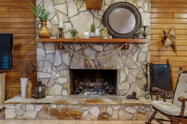 a spacious bedroom with a large bed a chandelier and dresser