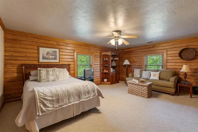 a view of a lake with a yard and a floor to ceiling window