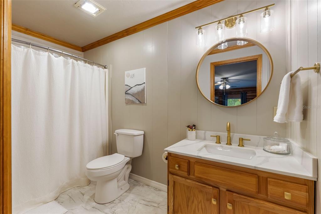 3771 184th Street Wellborn, FL 32094 - Photo 35 of 74 a bathroom with a toilet sink vanity and mirror