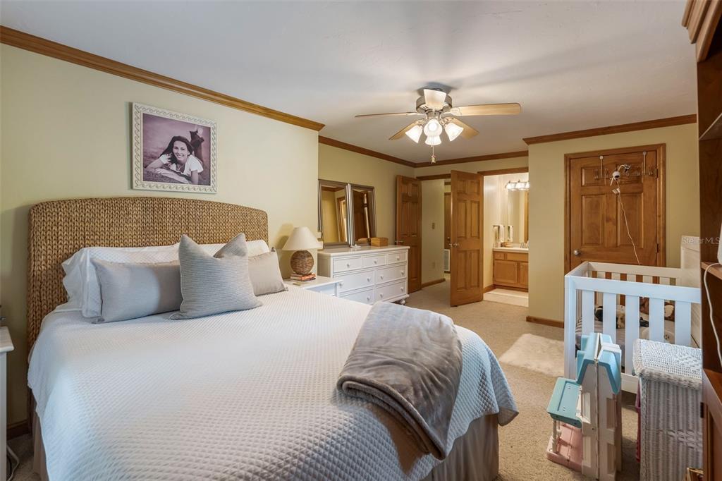 3771 184th Street Wellborn, FL 32094 - Photo 40 of 74 a spacious bedroom with a large bed a chandelier and dresser