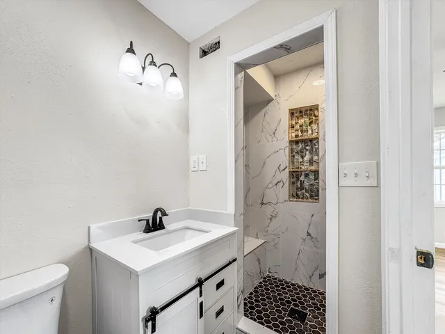 a bathroom with a sink a toilet and shower