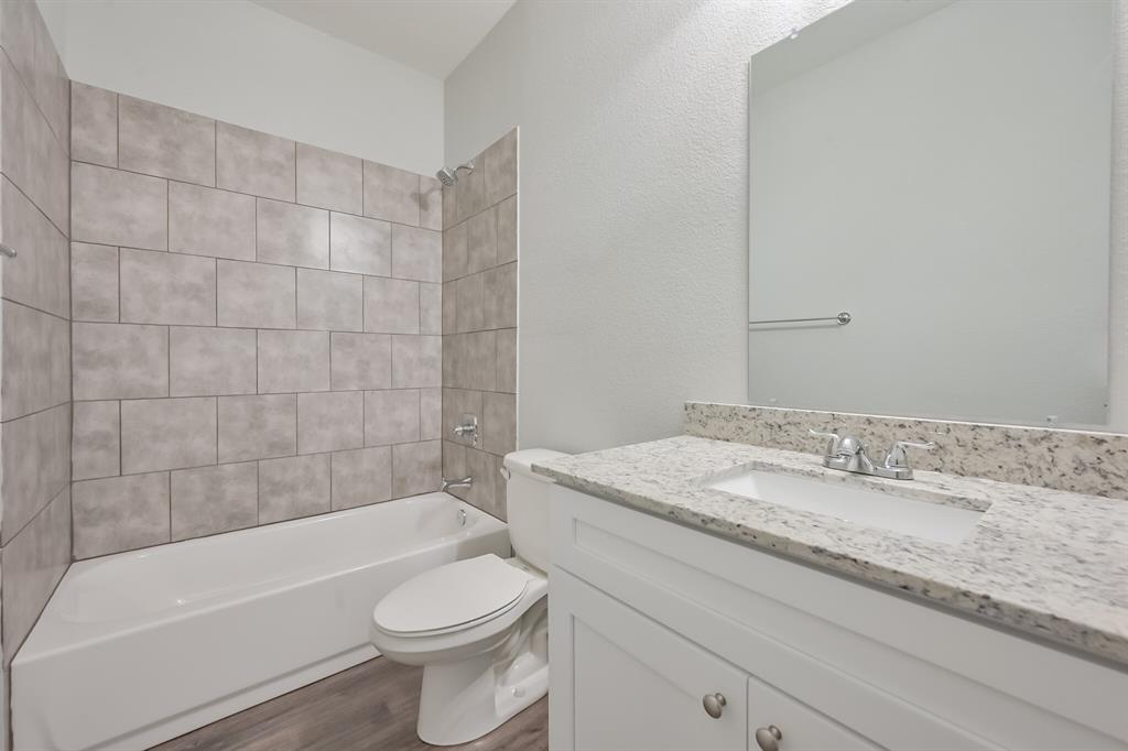 1716 East Powell Avenue Fort Worth, TX 76104 - Photo 13 of 13 a bathroom with a granite countertop toilet a sink and bathtub