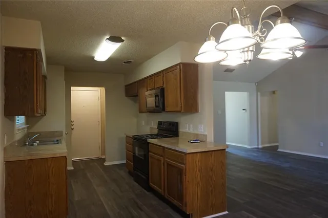 a kitchen with cabinets a counter space and a fireplace