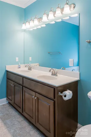 a utility room with a sink a cabinetry and chandelier