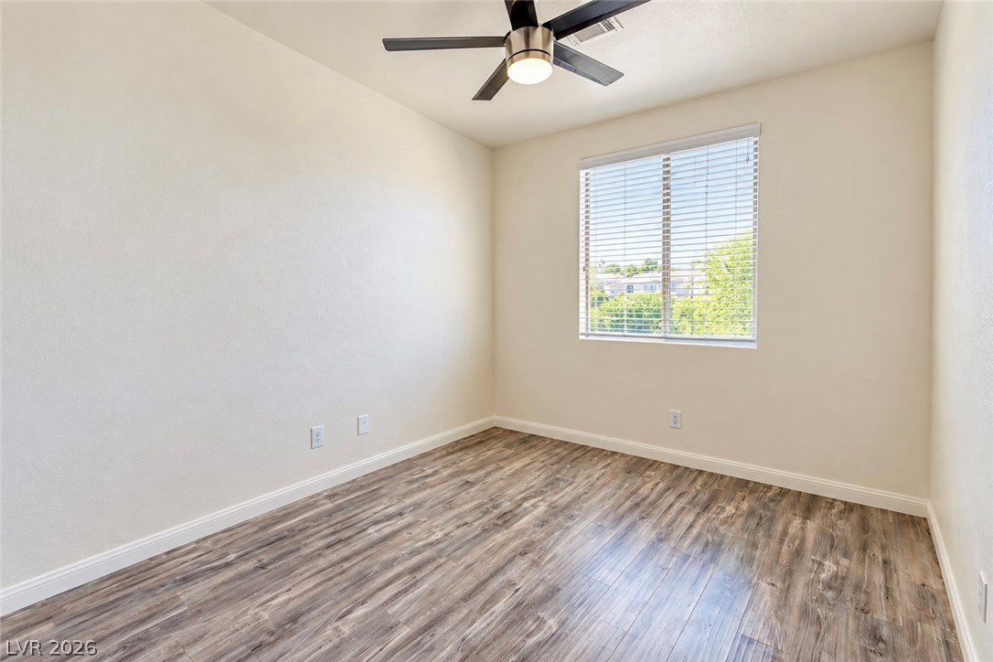 3104 Maple Ridge Court Henderson, NV 89052 - Photo 18 of 25 Rich wood-look flooring and a wide window create an inviting, versatile space.