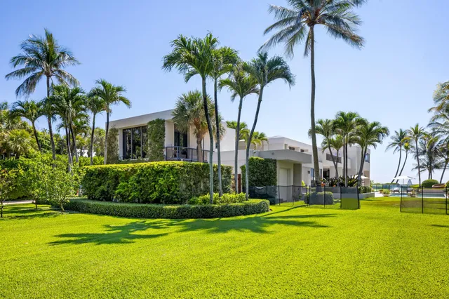 a view of a house with a big yard and large trees