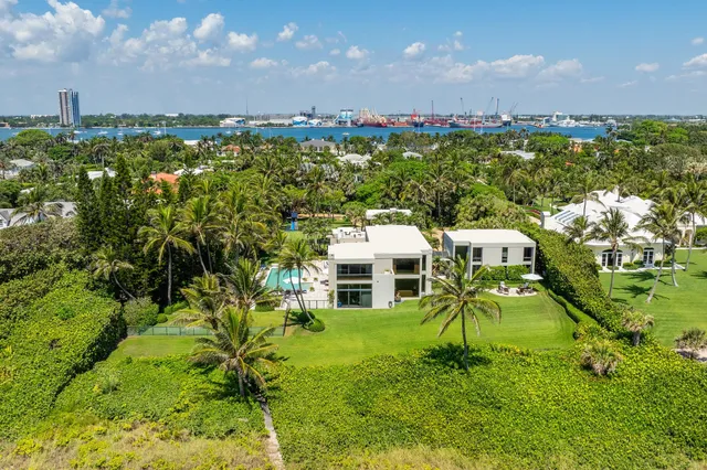a view of a house with a big yard and large trees