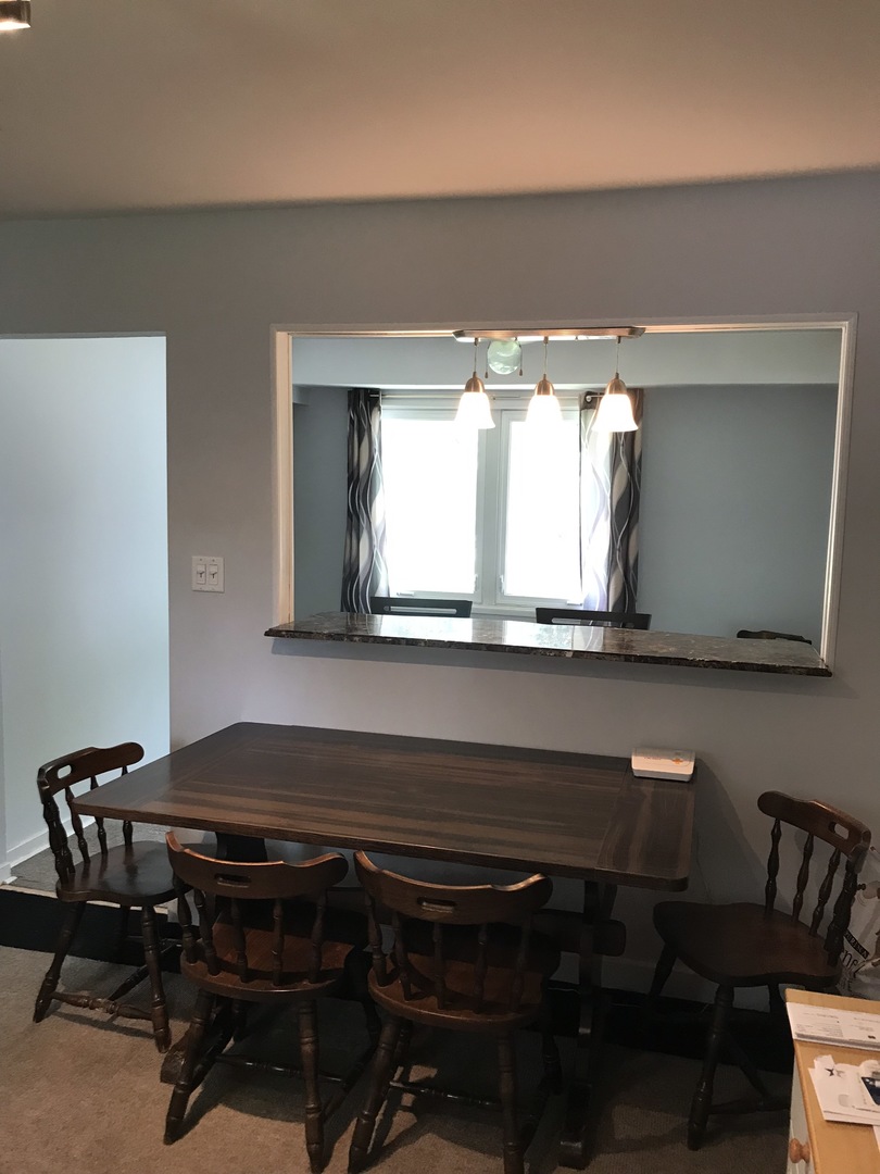 547 White Oak Road Bolingbrook, IL 60440 - Photo 9 of 19 a blue chair sitting in a kitchen next to a window