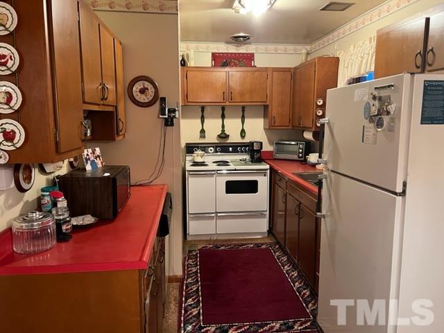 71 Roberts Grove Road Dunn, NC 28334 - Photo 5 of 23 a kitchen with a refrigerator and a stove top oven