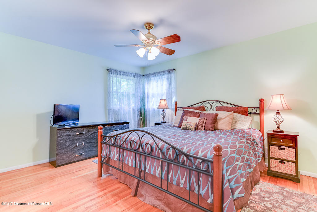116 Newbury Road Howell, NJ 07731 - Photo 12 of 19 a bedroom with a bed and a chandelier