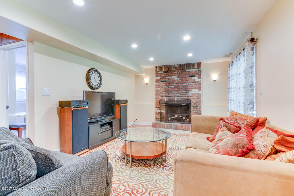 116 Newbury Road Howell, NJ 07731 - Photo 17 of 19 a living room with furniture a fireplace and a large window