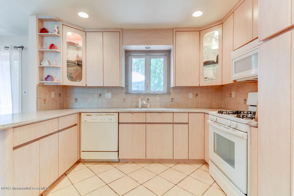 116 Newbury Road Howell, NJ 07731 - Photo 7 of 19 a kitchen with granite countertop white cabinets and white appliances
