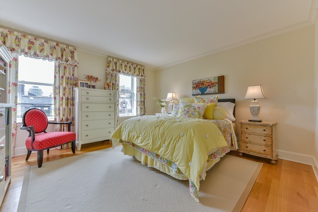 100 Beacon Street, Unit 7 Boston, MA 02116 - Photo 12 of 17 a spacious bedroom with a bed and a chair