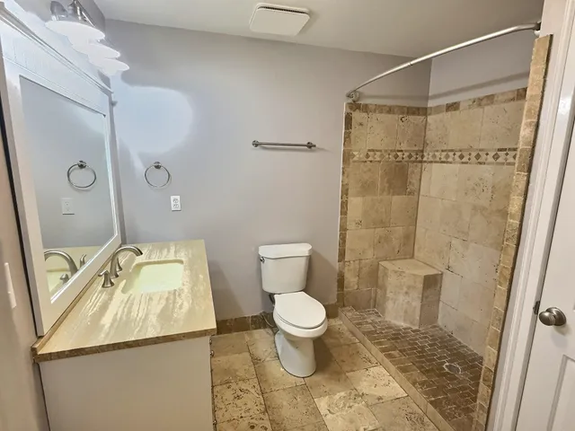 a bathroom with a toilet and a shower