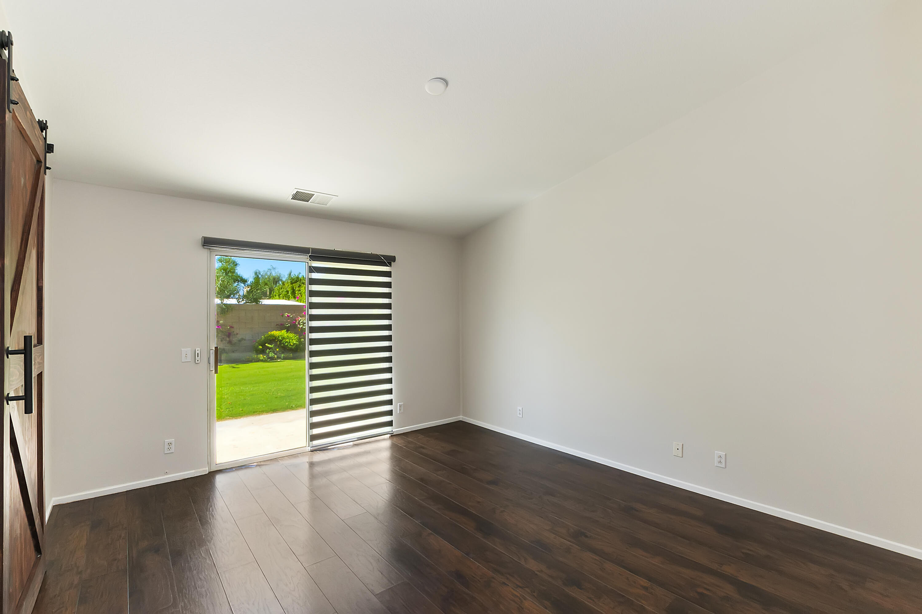80669 Freedom Avenue Indio, CA 92201 - Photo 21 of 30 an empty room with wooden floor and windows