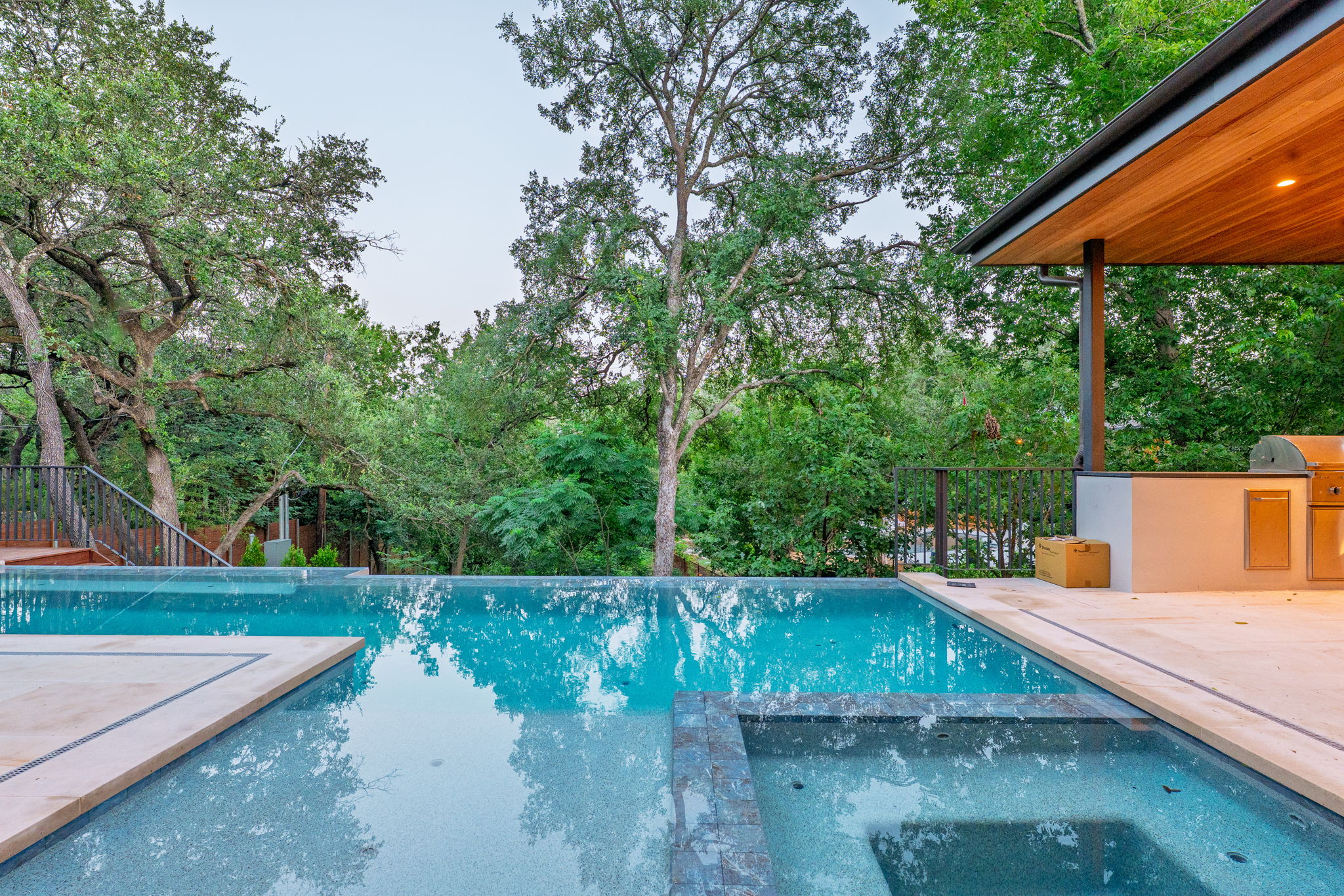 405 Honeycomb Ridge Austin, TX 78746 - Photo 3 of 15 An inviting pool and spa area with a built-in outdoor kitchen, perfect for entertaining.