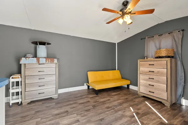 a bedroom with a dresser and a ceiling fan