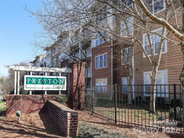 a view of a brick house with a yard and potted plants