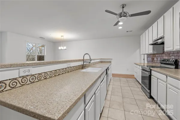 a kitchen with stainless steel appliances granite countertop a sink a oven and a refrigerator